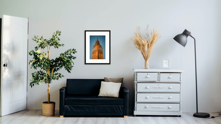 Framed and mounted photograph of the Elizabeth Tower, also known as Big Ben, in central London on a wall above a sofa.