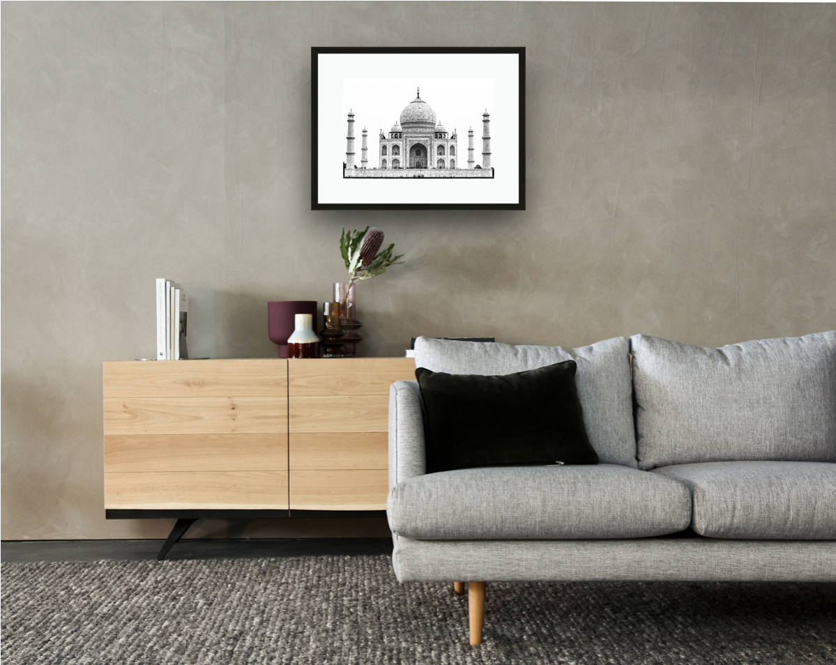 Framed and mounted black and white photograph of the Taj Mahal in Agra hanging on a wall above a sofa and cupboard